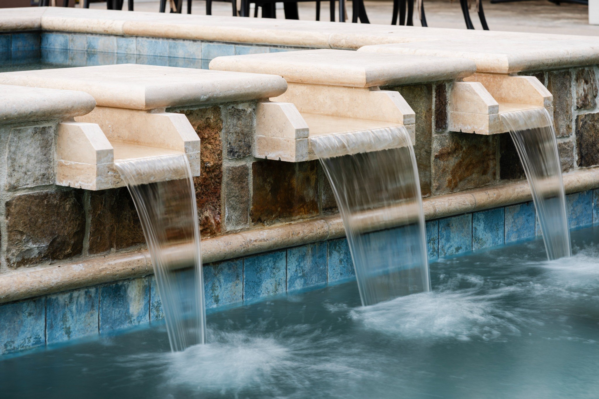 Close detail of stone spillways flowing into pool