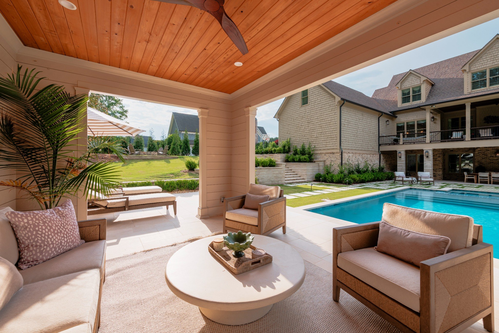 Covered outdoor living area overlooking a swimming pool