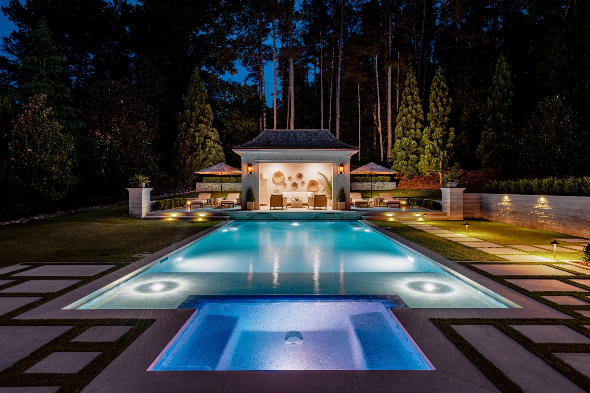 Pool and pavilion illuminated at blue hour