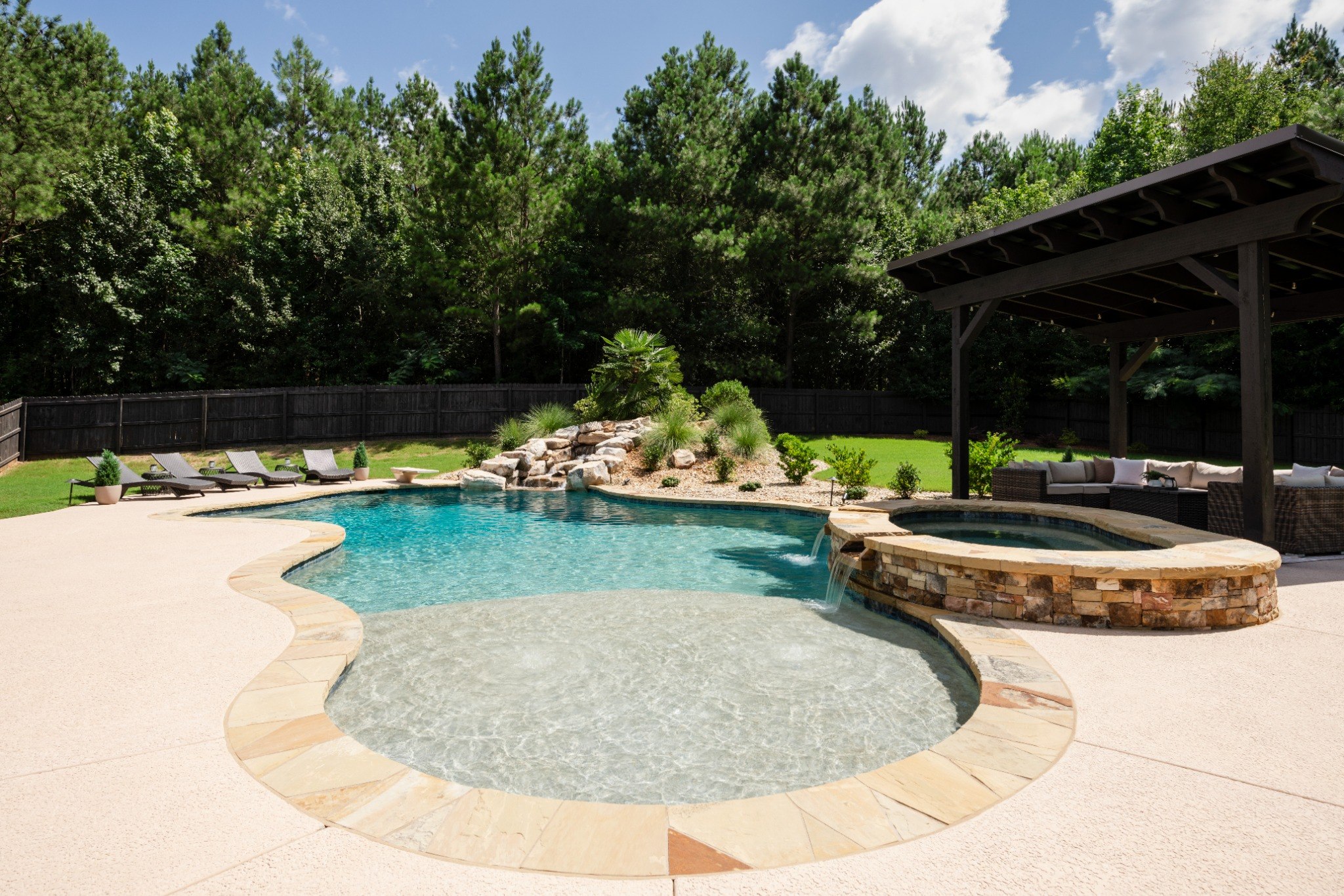 Freeform pool with spa, waterfall, and pavilion